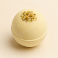 Lemon Soleil CBD bath bomb with chamomile botanicals on ivory background