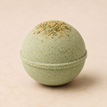 Sage and Citrus luxury bath bomb with dried herbs on ivory background